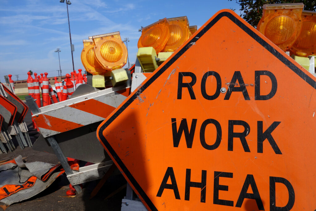 Orange sign that says road work ahead.