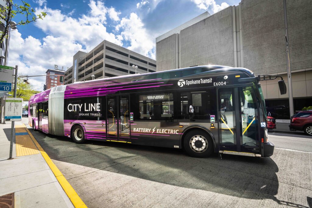 Purple Spokane City Line battery electric bus parked on a city street.