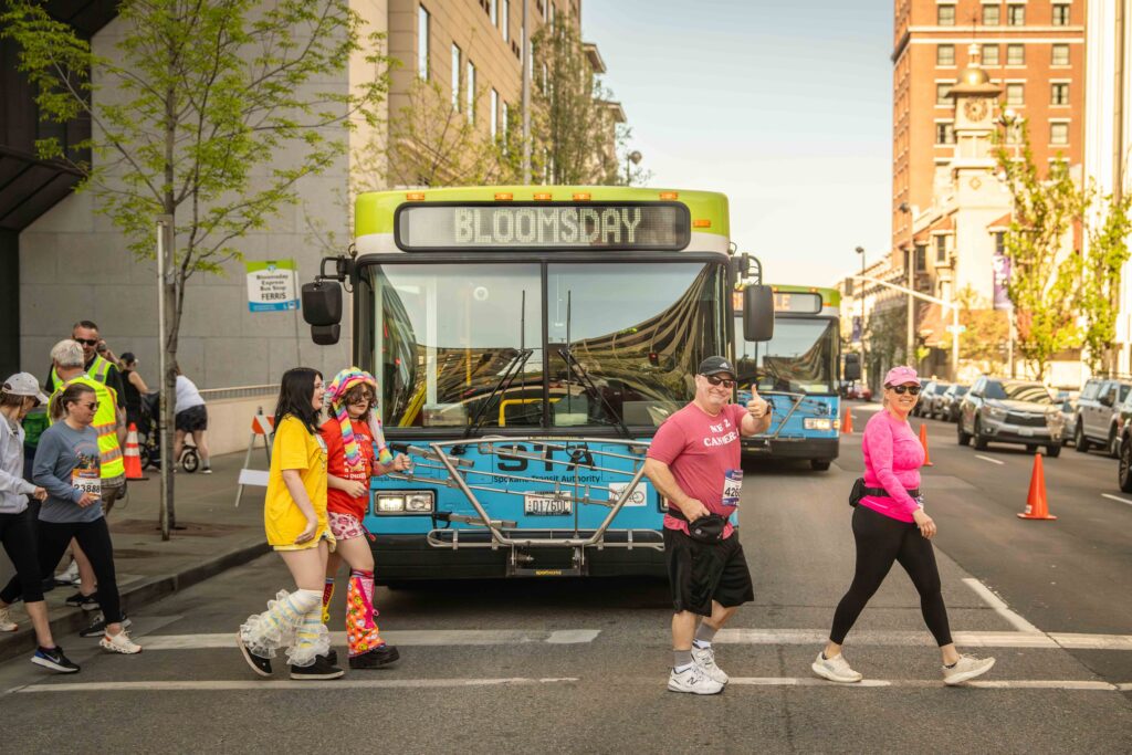 a group of Bloomsday runners walk by an STA bus.