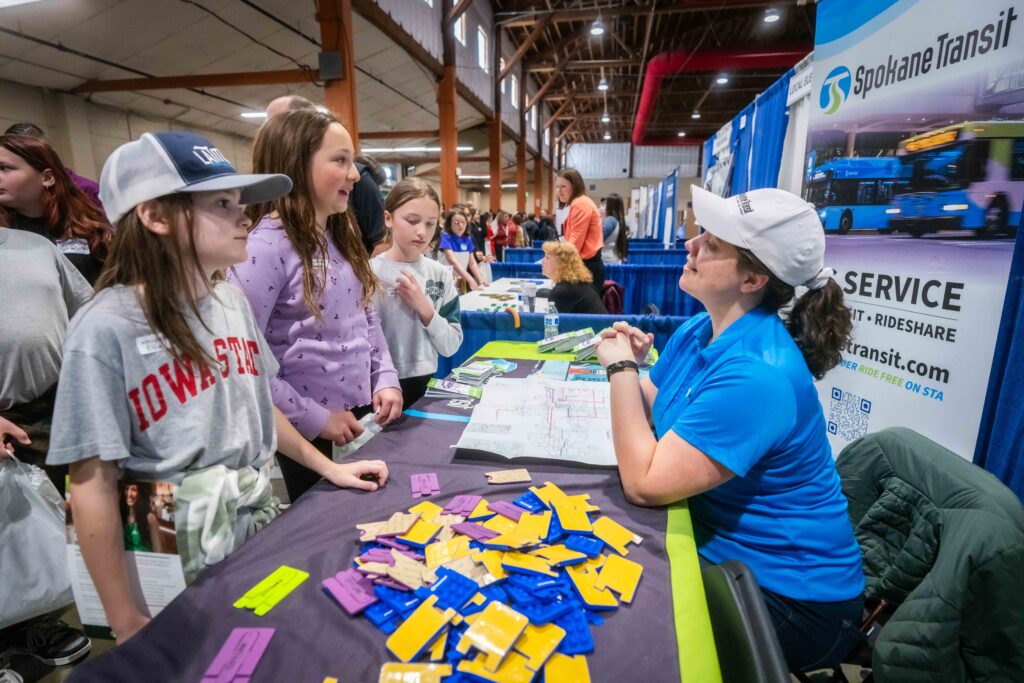 An outreach coordinator talks to STA elementary students at an outreach event.