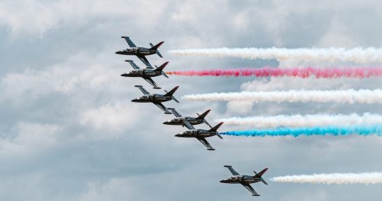 U.S. Air Force Patriots Jet Team aircraft fly in tight formation trailing colored smoke during the Wings Over Solano air show and open house at Travis Air Force Base, California, April 26, 2026. The demonstration highlights precision flying and coordination during aerial performances. (U.S. Air Force photo by Dennis Santarinala)
