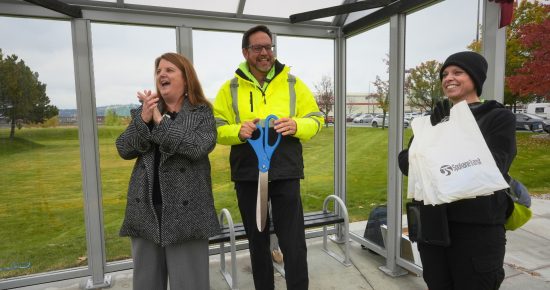 Carly celebrates the unveiling of a new STA bus shelter with two employees.
