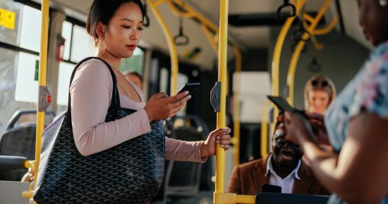 woman riding bus looking at her phone
