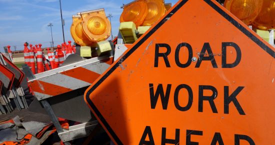 Orange sign that says road work ahead.